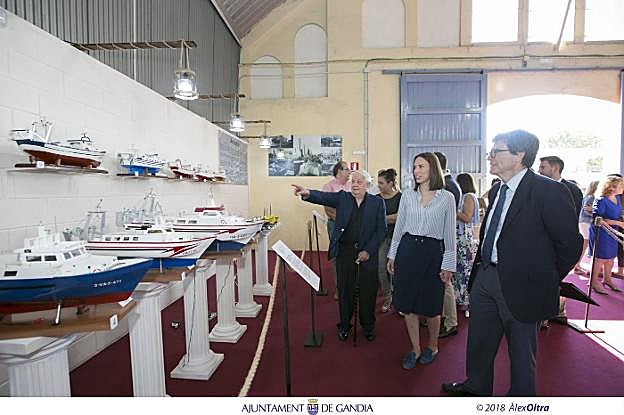 El creador de las maquetas, Manolo Estrela, enseña las embarcaciones a la alcaldesa Diana Morant y al presidente de la Autoridad Portuaria, Aurelio Martínez. 