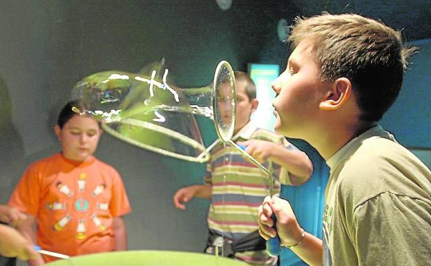 Varios niños realizan un experimento durante un taller educativo.