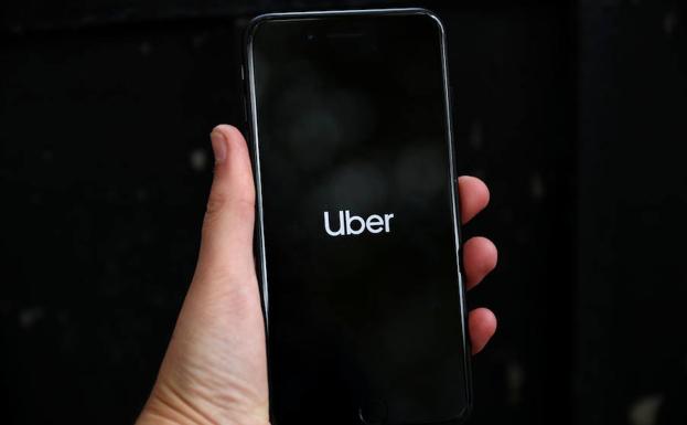 Un hombre abre la aplicación de Uber. 