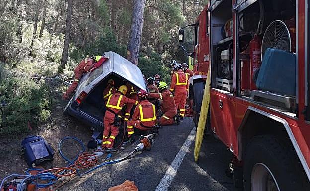 Imagen principal - Los bomberos trabajan para excarcelar a las personas atrapadas en la furgoneta.