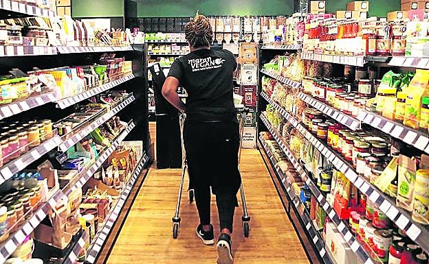 La dependienta de un súper vegano repone productos.