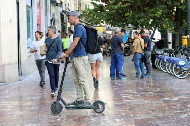 Un usuario de patinete en la plaza del Ayuntamiento. 