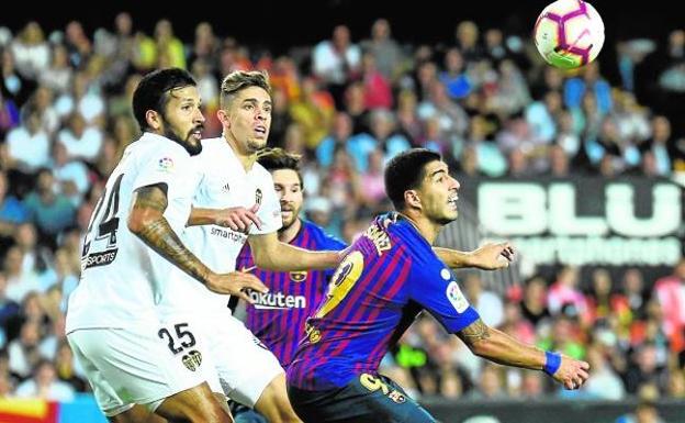 Garay y Paulista presionan a Luis Suárez en el útlimo partido frente al Barcelona en Mestalla.