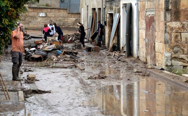 Varias personas trabajan para limpiar una de las zonas afectadas por las inundaciones.