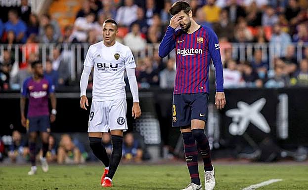 Piqué junto a Rodrigo durante el Valencia-Barça. 