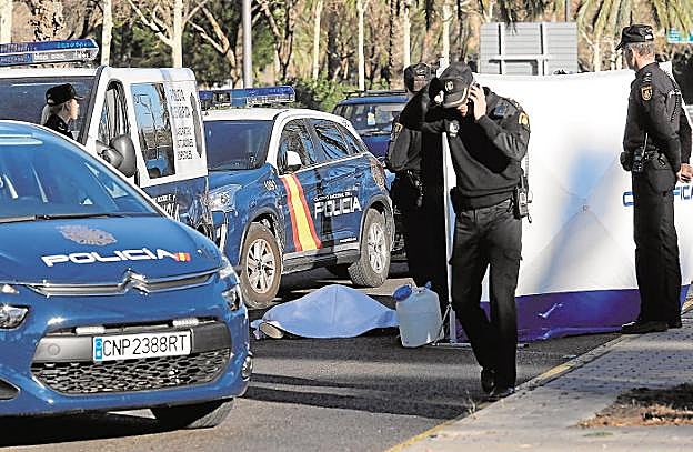 Varios policías junto al cadáver de la víctima en el bulevar sur. 