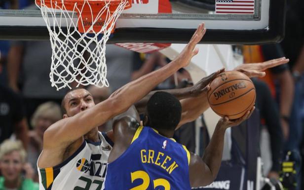 Rudy Gobert (i) de Utah Jazz en acción contra Draymond Green (d) de Golden State Warriors. 