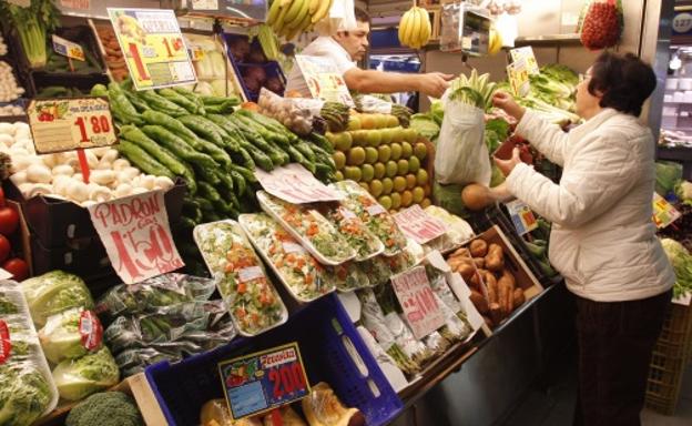 Una mujer comprando en la frutería. 