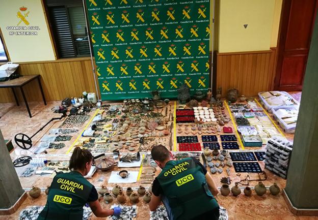 Dos agentes de la UCO preparan la exposición de las piezas confiscadas. 