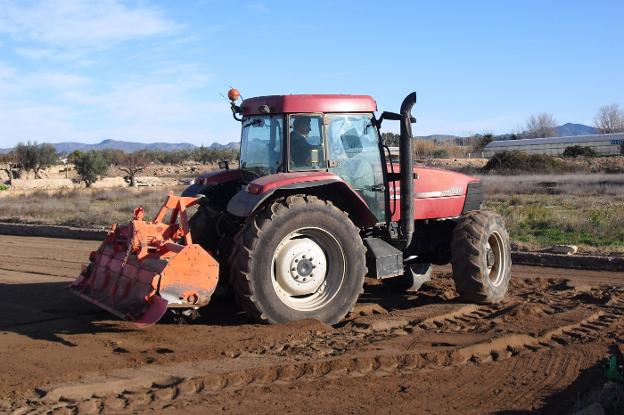 Un agricultor prepara la tierra de un campo con tractor y 'rotovátor' para realizar una plantación. 