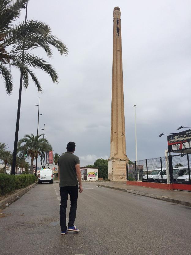 Un joven observa la deteriorada chimenea de Rajolars. 