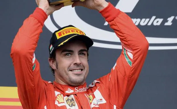 Fernando Alonso, piloto de Ferrari, levanta el trofeo de segundo clasificado en el podio del Gran Premio de Hungria de Formula 1. 