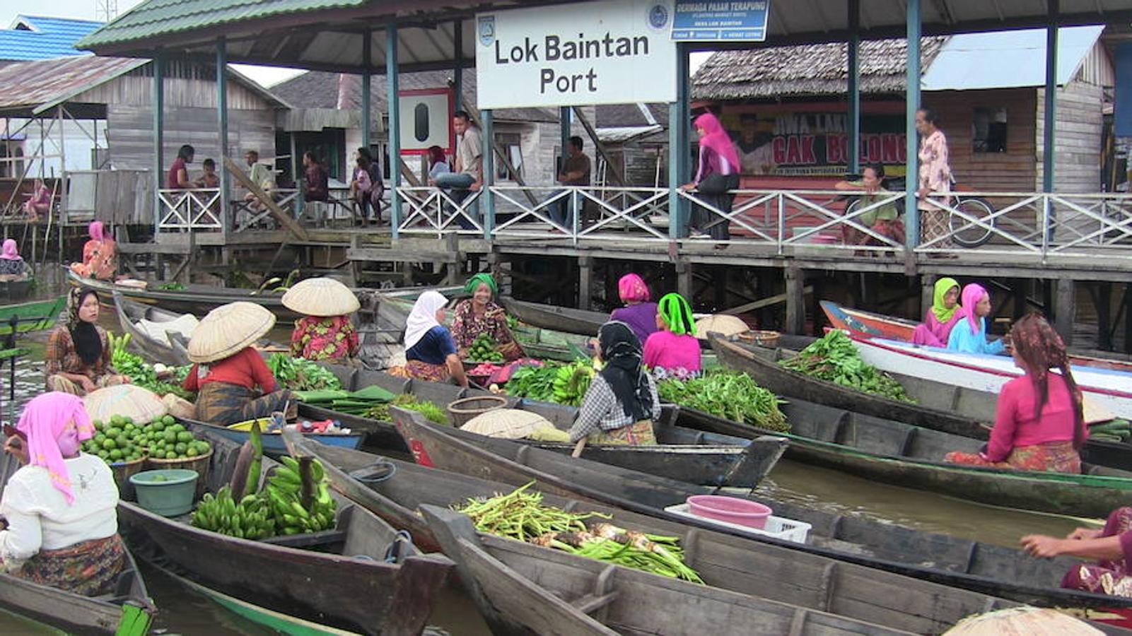 Lok Baintan (Indonesia) | El comercio local de la localidad indonesia de Banjarmasin, también conocida como el 'lugar de los mil ríos', discurre sobre las aguas del Martapura. Las mujeres son las dueñas del lugar: dirigen sus barcas, se encargan de la mercancía, de la compra y de la venta, formando una auténtica marea mercantil de color.