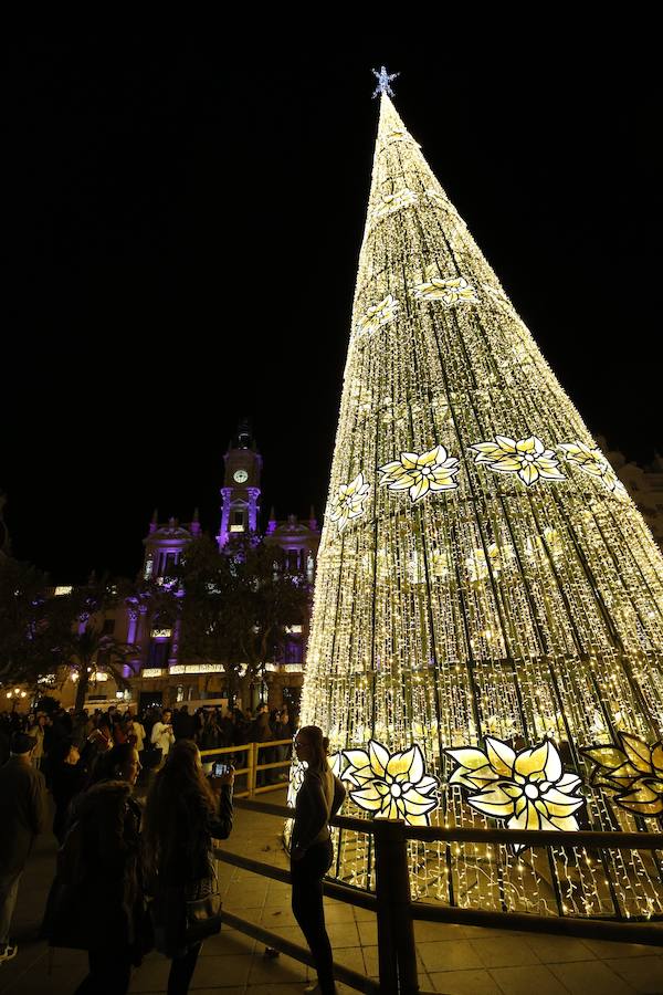 La Plaza del Ayuntamiento de Valencia ha vivido este viernes el encendido oficial de la iluminación navideña. Como gran novedad, este año otros dos barrios y dos pueblos de la ciudad se suman en la apuesta por descentralizar la decoración. Los dos barrios que este año estrenarán árbol de Navidad serán Benicalap y Malilla, sumándose así a las plazas de Patraix, Campanar, Benimaclet, Sant Valer (en Russafa), la Creu del Canyamelar y Doctor Collado (en Ciutat Vella), Orriols, Sant Marcel·lí y Abastos. Serán un total de 11 los árboles que se repartirán por toda la ciudad, además del de la Plaza del Ayuntamiento.