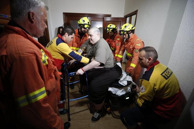 Teo logra levantarse de la camilla con ayuda de los sanitarios y los bomberos en su domicilio en Turís, ayer. 