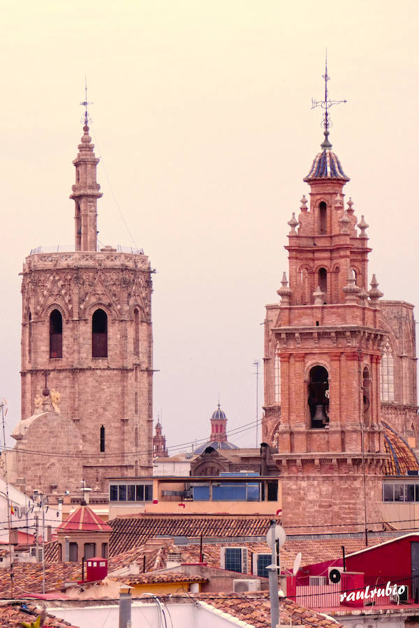 Valencia nunca deja de sorprender. Es habitual la imagen desde la calle de los múltiples campanarios que se encuentran en la ciudad. En el centro histórico aún encontramos más torreones eclesiásticos. Pero, ¿cómo se ve la ciudad desde el cobijo de las campanas?. Raúl Rubio, de la Associació de Mestres Campaners, ha inmortalizado esa visión de la que poca gente puede disfrutar: Valencia desde sus campanarios. Ver la plaza de San Agustín con una perspectiva diferente, contemplar el centro de la ciudad desde Santa Catalina, admirar Valencia desde las campanas del Real Monasterio de la Santísima Trinidad son algunos de las panorámicas exquisitas casi exclusivas para campaneros. La ciudad se redescubre desde las alturas, desde la perspectiva de gárgolas, campanas y tejados. Así es Valencia desde sus campanarios.