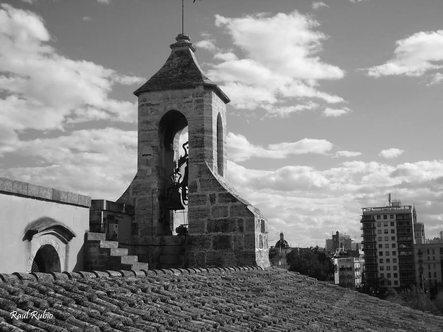 Valencia nunca deja de sorprender. Es habitual la imagen desde la calle de los múltiples campanarios que se encuentran en la ciudad. En el centro histórico aún encontramos más torreones eclesiásticos. Pero, ¿cómo se ve la ciudad desde el cobijo de las campanas?. Raúl Rubio, de la Associació de Mestres Campaners, ha inmortalizado esa visión de la que poca gente puede disfrutar: Valencia desde sus campanarios. Ver la plaza de San Agustín con una perspectiva diferente, contemplar el centro de la ciudad desde Santa Catalina, admirar Valencia desde las campanas del Real Monasterio de la Santísima Trinidad son algunos de las panorámicas exquisitas casi exclusivas para campaneros. La ciudad se redescubre desde las alturas, desde la perspectiva de gárgolas, campanas y tejados. Así es Valencia desde sus campanarios.