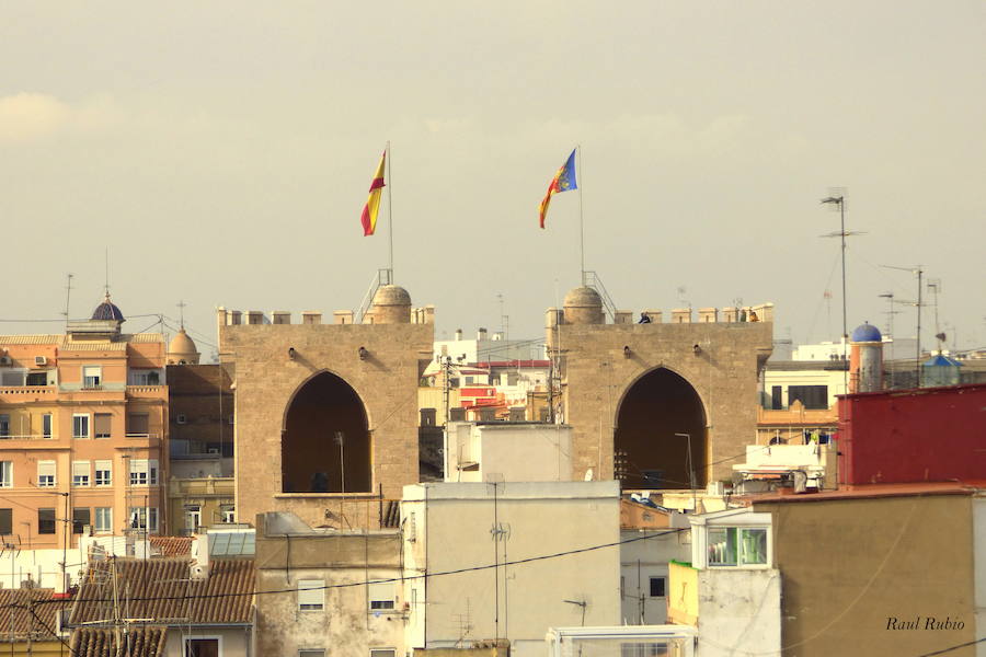 Valencia nunca deja de sorprender. Es habitual la imagen desde la calle de los múltiples campanarios que se encuentran en la ciudad. En el centro histórico aún encontramos más torreones eclesiásticos. Pero, ¿cómo se ve la ciudad desde el cobijo de las campanas?. Raúl Rubio, de la Associació de Mestres Campaners, ha inmortalizado esa visión de la que poca gente puede disfrutar: Valencia desde sus campanarios. Ver la plaza de San Agustín con una perspectiva diferente, contemplar el centro de la ciudad desde Santa Catalina, admirar Valencia desde las campanas del Real Monasterio de la Santísima Trinidad son algunos de las panorámicas exquisitas casi exclusivas para campaneros. La ciudad se redescubre desde las alturas, desde la perspectiva de gárgolas, campanas y tejados. Así es Valencia desde sus campanarios.