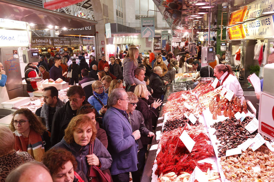 Lleno hasta la bandera. Así ha estado este sábado el centro de Valencia con curiosos que querían fotografiar todos los escaparates, pero sobre todo con gente haciendo las compras de Nochevieja. Uno de los puntos de encuentro que ha registrado el cartel de 'completo' ha sido una vez más el Mercado Central. El marisco, salazones, frutos secos y quesos variados llenan las cestas a dos días del Fin de Año. 