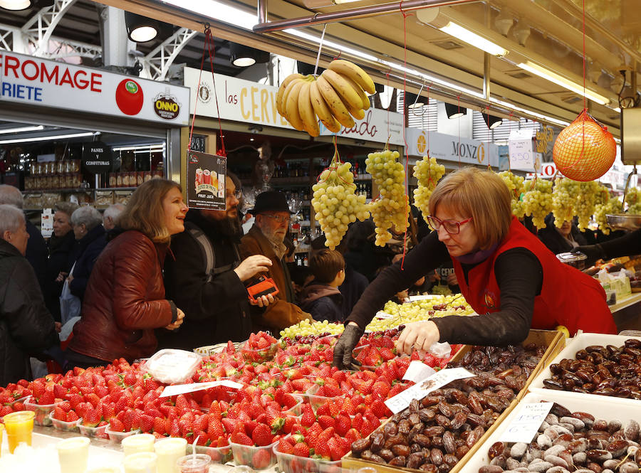 Lleno hasta la bandera. Así ha estado este sábado el centro de Valencia con curiosos que querían fotografiar todos los escaparates, pero sobre todo con gente haciendo las compras de Nochevieja. Uno de los puntos de encuentro que ha registrado el cartel de 'completo' ha sido una vez más el Mercado Central. El marisco, salazones, frutos secos y quesos variados llenan las cestas a dos días del Fin de Año. 