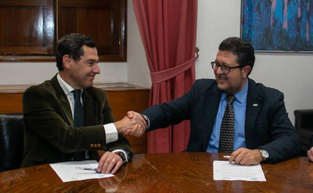 El presidente del PP-A, Juanma Moreno y el portavoz de Vox en el Parlamento de Andalucía, Francisco Serrano estrechan las manos tras firmar un acuerdo de investidura.