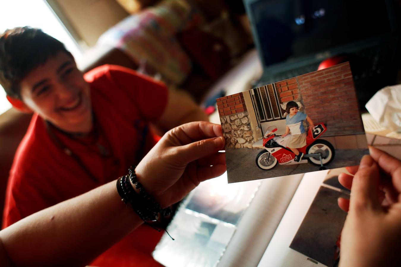 Gabriel, a los 16 años, se ríe mientras su madre Mariely muestra fotos de él cuando era niña en su casa en Madrid, (27 de mayo de 2015). "Mi madre me pilló vendándome el pecho una mañana y le dije que no me sentía cómoda con el sexo que me asignaron al nacer. Ella no entendió lo que dije, pero luego me dijo que si decidía usar un jarrón de flores en la cabeza, tampoco lo entendería, pero lo aceptaría y se uniría a mí haciendo lo mismo ", relata Gabriel.