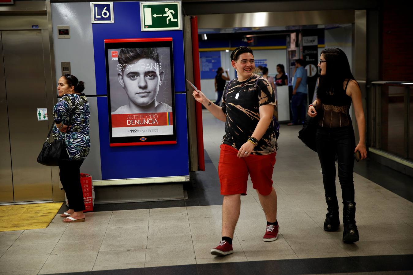 Gabriel muestra a un amigo una foto de sí mismo con la frase "Soy trans" como parte de una campaña pública para combatir los delitos de odio en una estación de metro en Madrid, el 1 de julio de 2016. "Después de hacer la campaña de fobia LGBT, algunos comenzaron a escribir comentarios de odio en mi cuenta de Instagram. Cosas como, 'después de que acabemos contigo, no necesitarás un cambio de sexo'. Lo denuncié y estamos esperando el juicio".