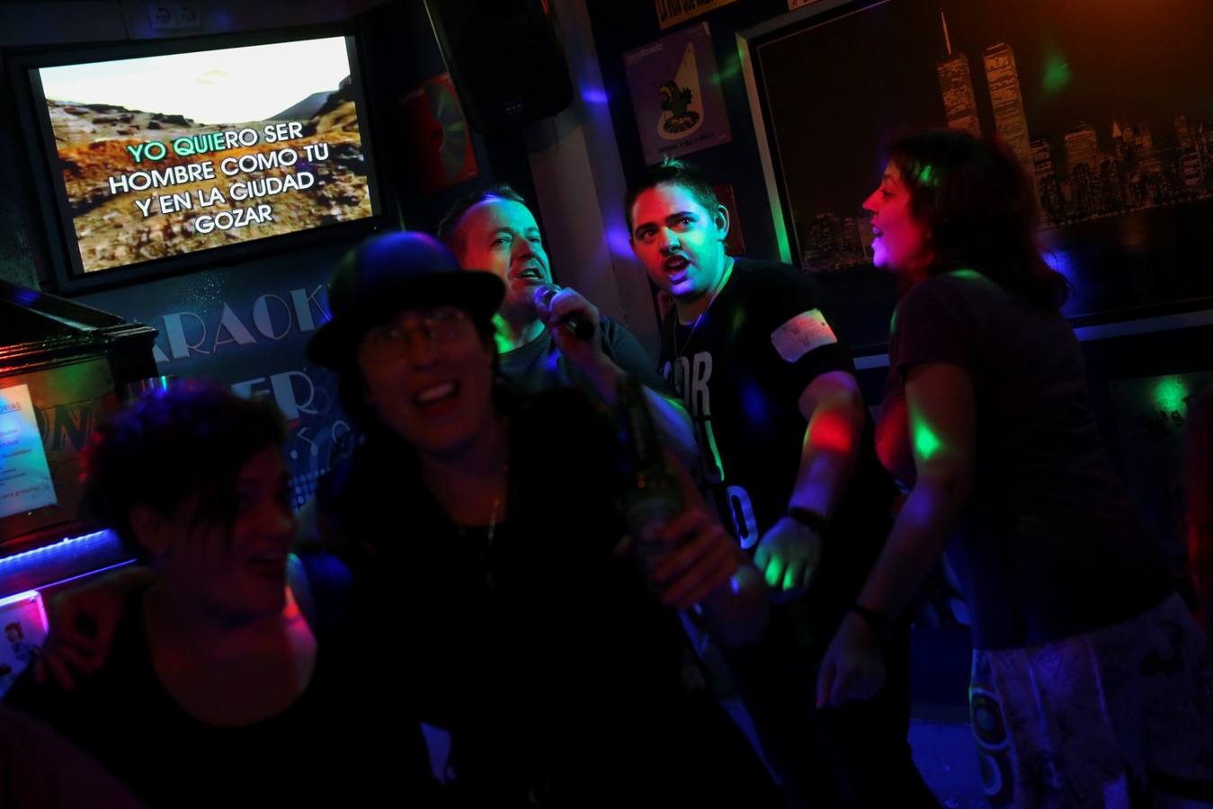 Con 18 años, 8 años, en un karaoke con amigos, el 22 de octubre de 2016. Las letras en la pantalla dicen: "Quiero ser un hombre como tú y en la ciudad gozar".