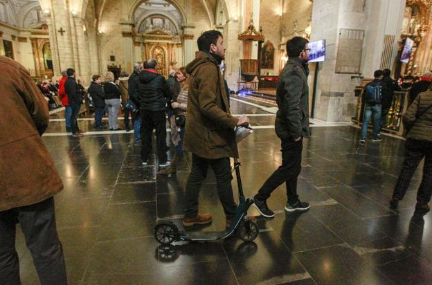 Un usuario de patinete, este martes en la catedral con el vehículo. 