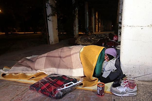 Una persona en situación de indigencia duerme en la calle en pleno invierno. 