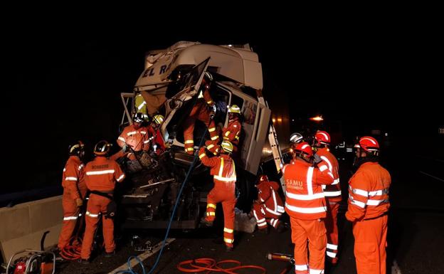 Bomberos, en el rescate del conductor atrapado en su camión.