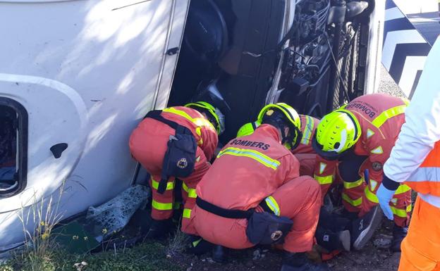 Los bomberos, durante los trabajos de rescate del conductor atrapado en el camión.