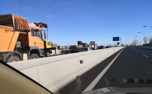 En la imagen, el trailer que ha causado el accidente traspasa la carga a otro camión, provocando el atasco en la vía.