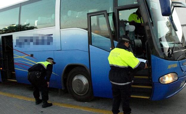 Policías locales inspeccionan un autobús escolar, en una imagen de archivo.