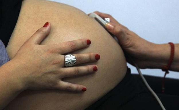 Una mujer embarazada sometiéndose a una revisión. 