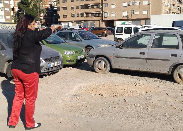 Una usuaria del aparcamiento explica el material que usan los vecinos para allanar el terreno. 