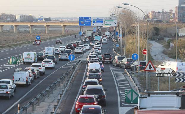 Coches y camiones circulan en una congestión de la V-21