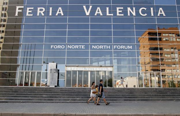 Varias personas pasan ante Feria Valencia. 