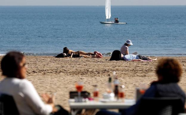 Personas disfrutando del buen tiempo y de las altas temperaturas en la playa de la Malvarrosa. 