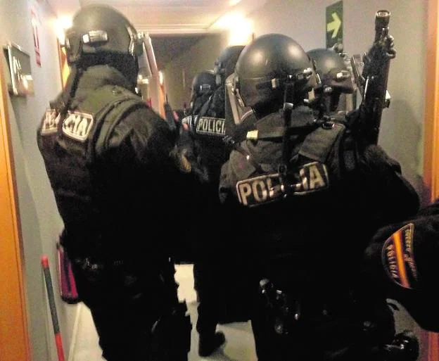 Policías del Grupo Operativo Especial de Seguridad (GOES) se preparan para irrumpir en un piso. 