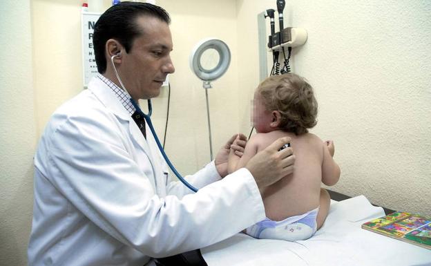 Un pediatra realiza una exploración a un bebé.