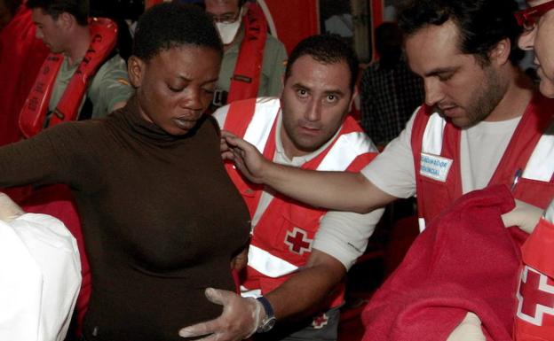 Voluntarios de la Cruz Roja atiende atienden a una mujer embarazada superviviente frente a la costa de Almería