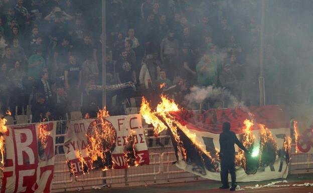Radicales del Panathinaikos queman banderas del Olympiacos. 