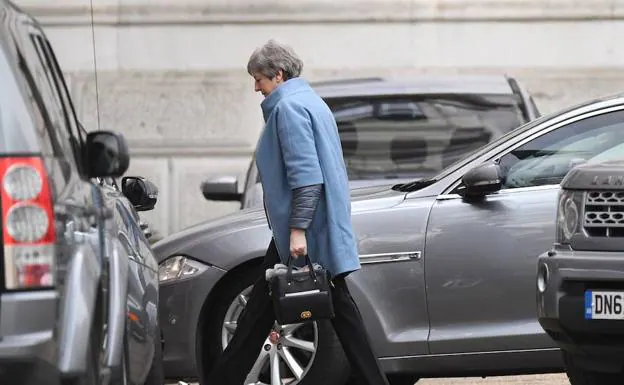La primera ministra británica, Theresa May, camina haca la entrada trasera de su residencia oficial este lunes en el centro de Londres (Reino Unido).