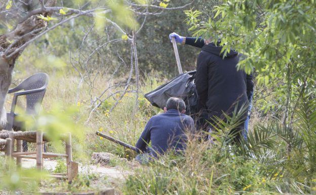 Un equipo de investigadore sujetan un palo hallado en la caseta de Godella.