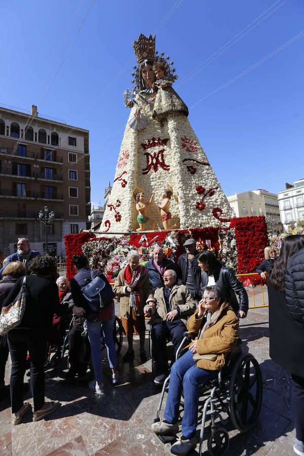 La Ofrenda concluyó este lunes después de que miles de falleros desfilaran para llevar las flores a la Virgen de los Desamparados. Este martes, a la luz del día se ha desvelado ante los ojos de los valencianos el aspecto definitivo del manto de la 'Geperudeta'. Claveles blancos, rojos y rosas componen componen el diseño del vestidor Rafael Chordá. Un floreado manto con el blanco como color predominante y que preside estos días la plaza de la Virgen, ante su basílica.