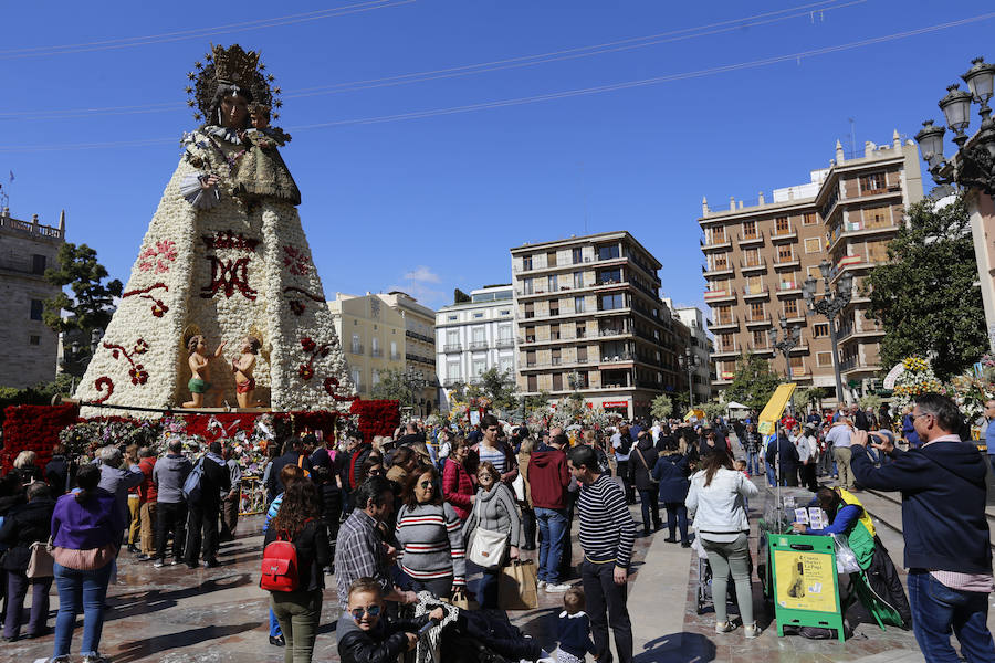 La Ofrenda concluyó este lunes después de que miles de falleros desfilaran para llevar las flores a la Virgen de los Desamparados. Este martes, a la luz del día se ha desvelado ante los ojos de los valencianos el aspecto definitivo del manto de la 'Geperudeta'. Claveles blancos, rojos y rosas componen componen el diseño del vestidor Rafael Chordá. Un floreado manto con el blanco como color predominante y que preside estos días la plaza de la Virgen, ante su basílica.