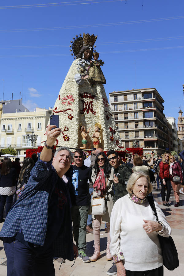 La Ofrenda concluyó este lunes después de que miles de falleros desfilaran para llevar las flores a la Virgen de los Desamparados. Este martes, a la luz del día se ha desvelado ante los ojos de los valencianos el aspecto definitivo del manto de la 'Geperudeta'. Claveles blancos, rojos y rosas componen componen el diseño del vestidor Rafael Chordá. Un floreado manto con el blanco como color predominante y que preside estos días la plaza de la Virgen, ante su basílica.