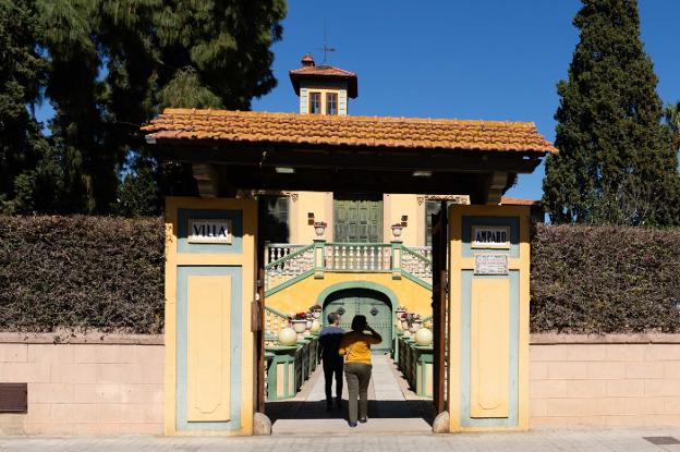 Dos vecinos acceden por la puerta principal de Villa Amparo. 