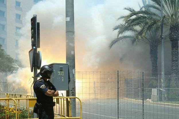 Un policía vigila el perímetro de seguridad durante el lanzamiento de una mascletà de Hogueras en la Plaza de los Luceros. 